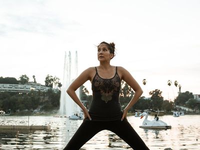 Person doing a balanced yoga stretch near window.